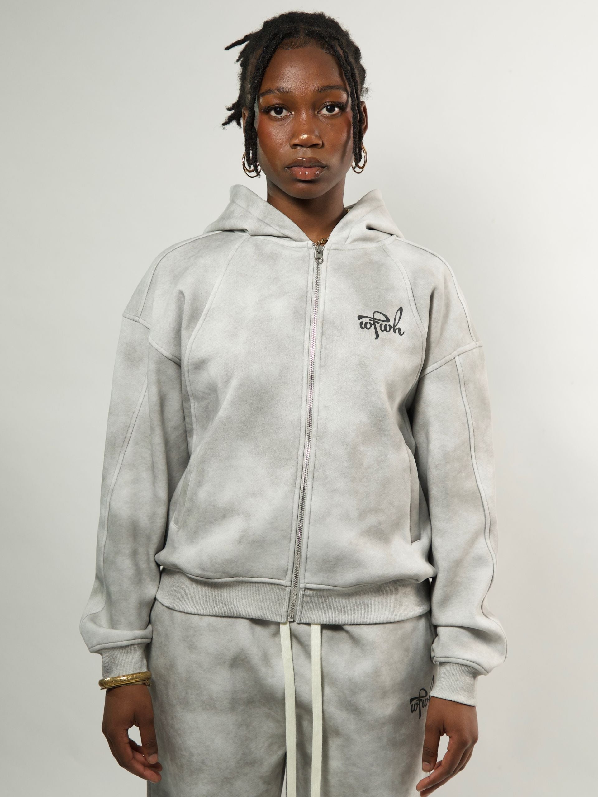 model wearing a gray zipper with wfwh logo on a plain background