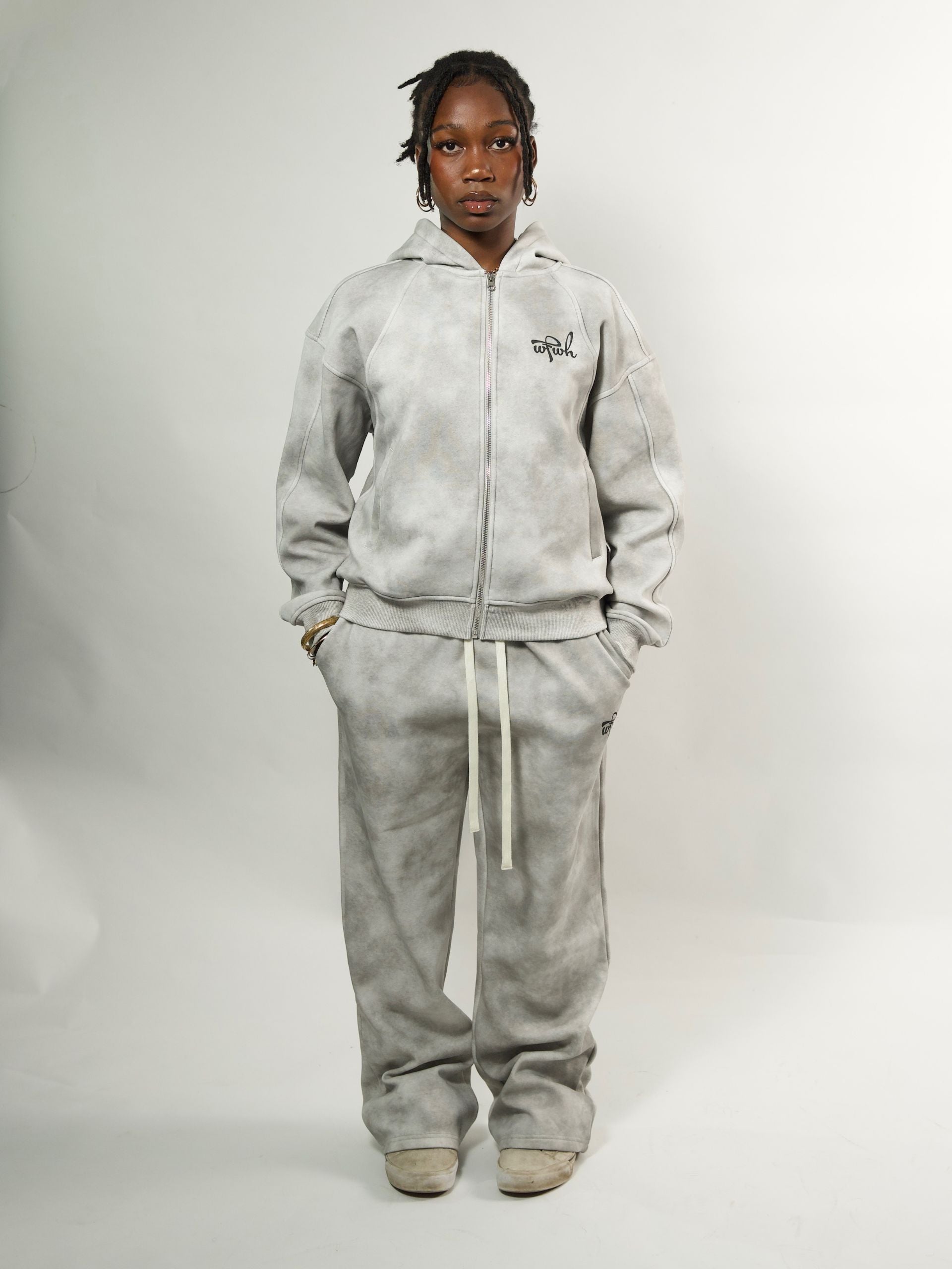 moodel wearing a wfwh gray hoodie and matching pants on a white background
