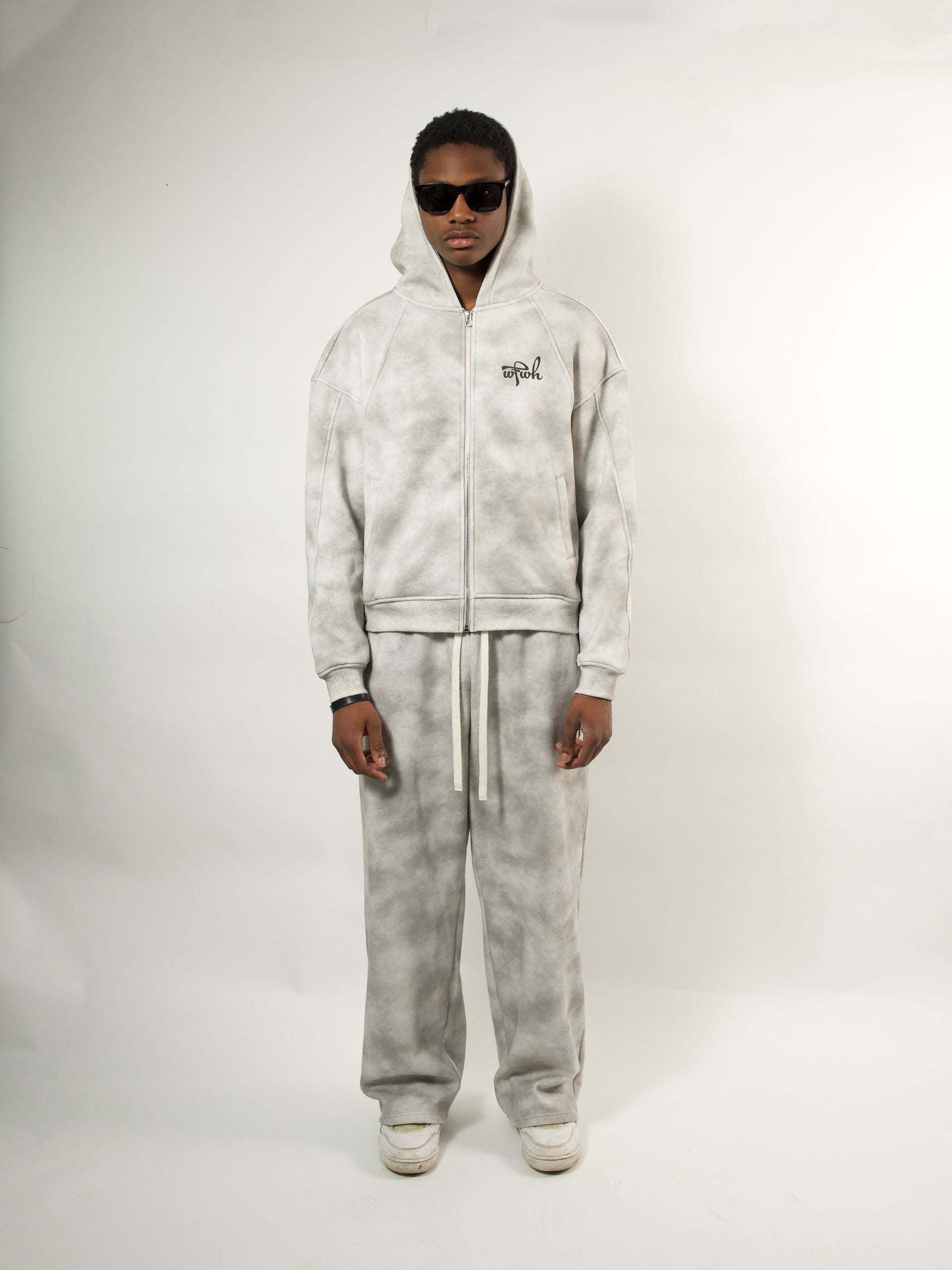 Person wearing a wfwh gray tie-dye tracksuit with a brand logo on a white background